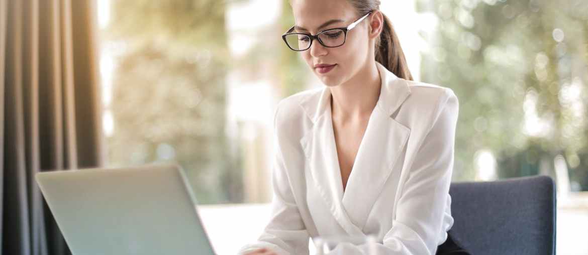 Image of a woman researching the best alternatives to Power Automate on her laptop
