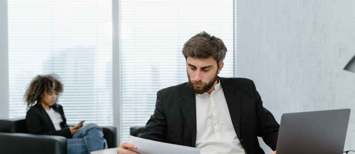Image of a man sitting at a desk analyzing alternatives to uipath on the computer