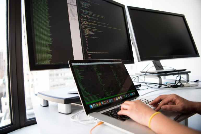 Imagem de computadores mostrando codigos de teste de integracao